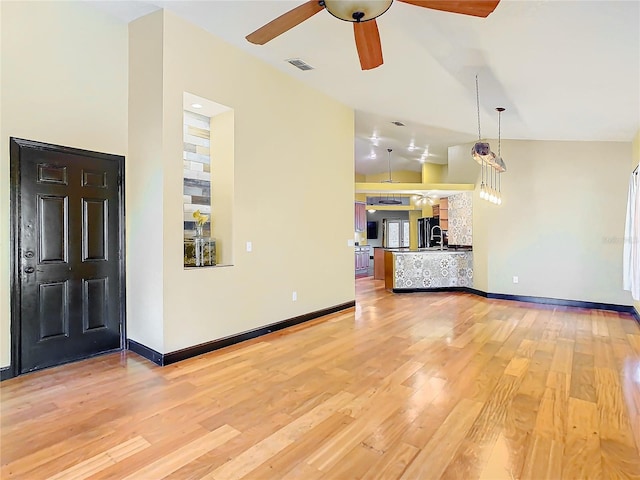 unfurnished living room featuring hardwood / wood-style flooring, vaulted ceiling, and ceiling fan