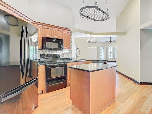 kitchen featuring black appliances, ceiling fan, light wood-type flooring, and kitchen peninsula