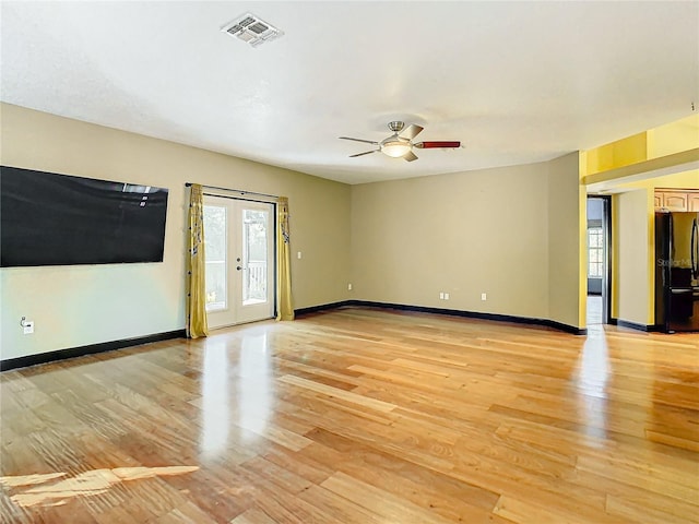 unfurnished room featuring ceiling fan, french doors, and light wood-type flooring