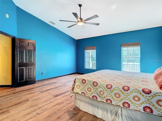 bedroom featuring ceiling fan, lofted ceiling, light wood-type flooring, and multiple windows