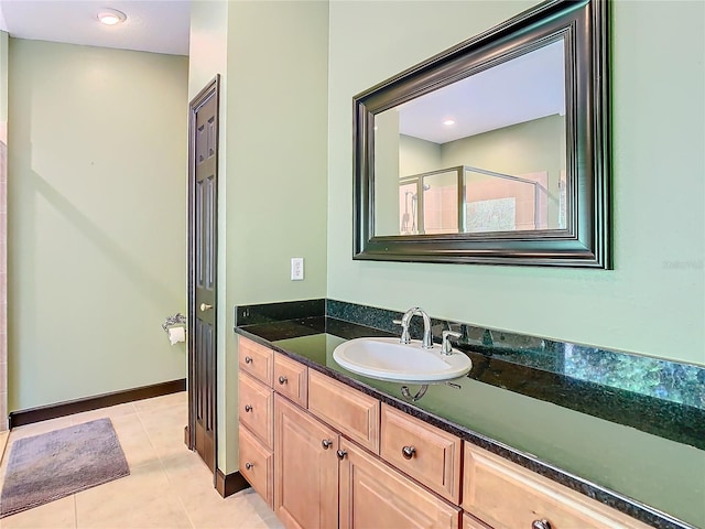 bathroom featuring tile patterned flooring, vanity, and a shower with shower door