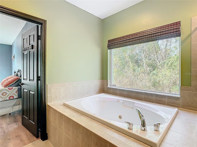 bathroom featuring tiled tub, a healthy amount of sunlight, vaulted ceiling, and hardwood / wood-style flooring