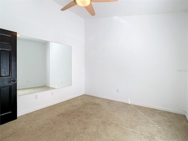 carpeted spare room featuring ceiling fan