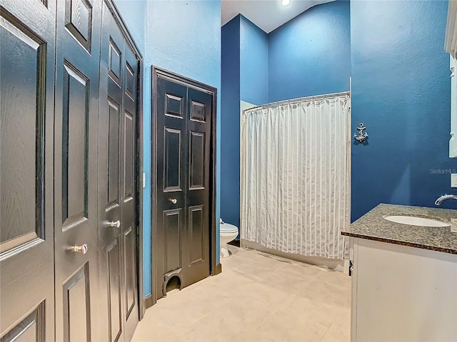 bathroom with tile patterned floors, walk in shower, vanity, and toilet