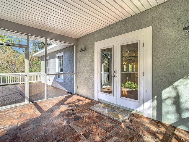 unfurnished sunroom with wood ceiling and french doors