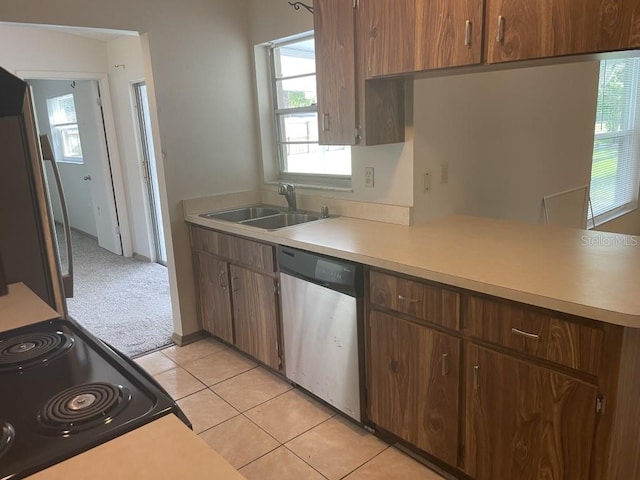 kitchen featuring dishwasher, stove, sink, light tile patterned floors, and fridge