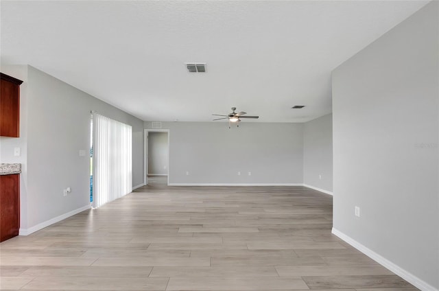 unfurnished living room featuring ceiling fan and light wood-type flooring