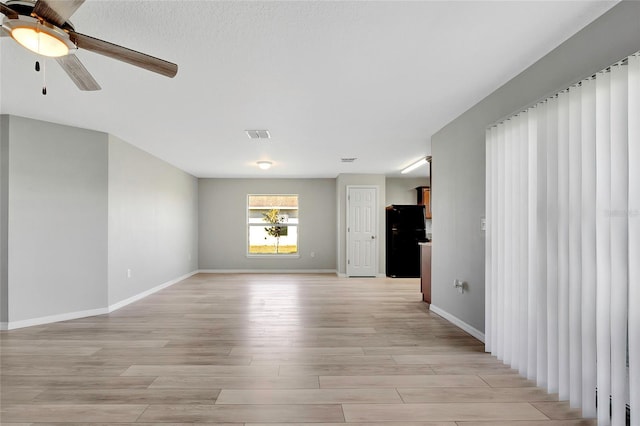 spare room featuring light hardwood / wood-style flooring and ceiling fan