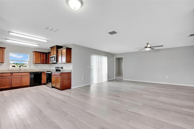 kitchen with ceiling fan, sink, stainless steel appliances, a textured ceiling, and light wood-type flooring