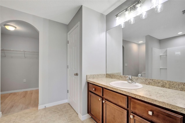 bathroom with hardwood / wood-style floors, vanity, and walk in shower