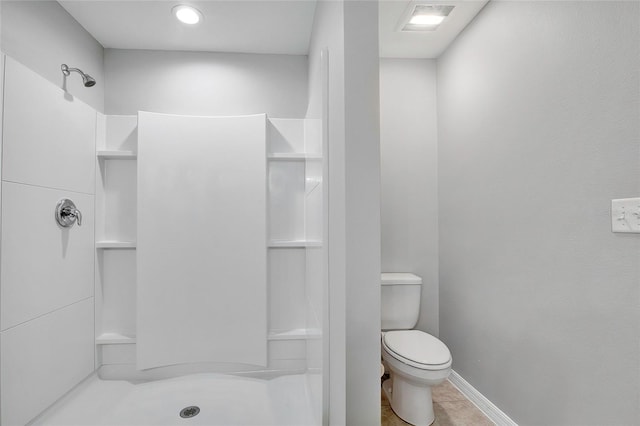 bathroom featuring tile patterned floors, toilet, and walk in shower