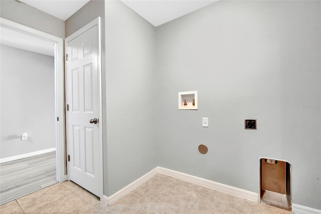 washroom with hookup for an electric dryer, hookup for a washing machine, and light tile patterned flooring