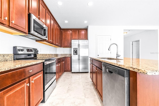 kitchen with light tile patterned floors, sink, light stone counters, and appliances with stainless steel finishes