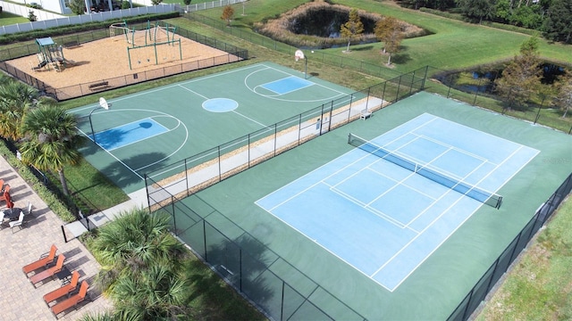 view of sport court featuring tennis court and a yard