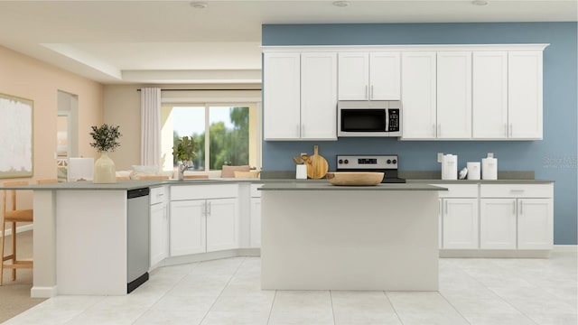 kitchen with white cabinets, stainless steel appliances, sink, and a center island