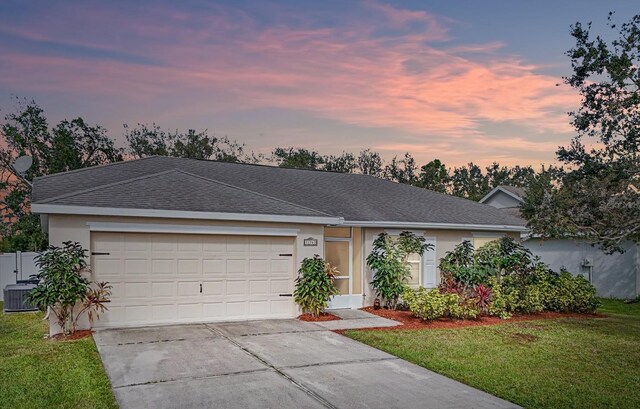 ranch-style house with central AC, a lawn, and a garage