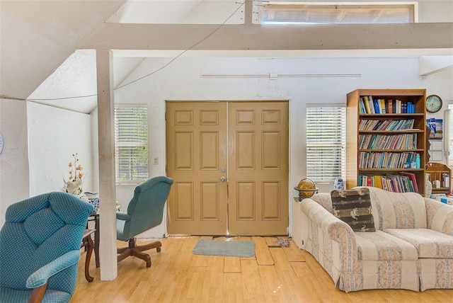 living area with hardwood / wood-style floors, vaulted ceiling, and plenty of natural light