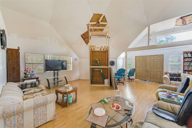 living room featuring light hardwood / wood-style floors and high vaulted ceiling