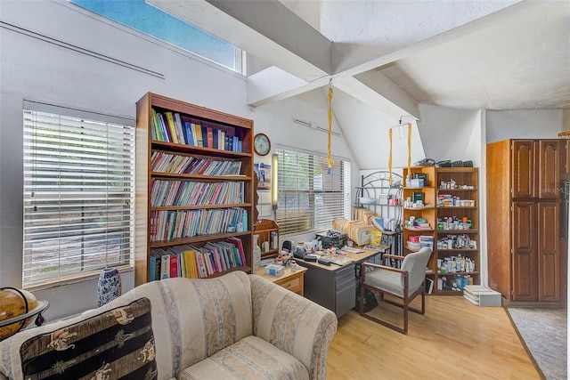 office space featuring vaulted ceiling with beams, light hardwood / wood-style flooring, and plenty of natural light