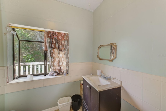 bathroom with vanity and tile walls