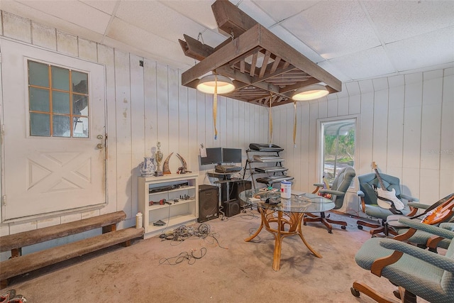 office space with wooden walls and a drop ceiling