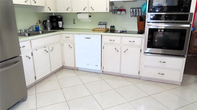 kitchen with sink, white cabinets, light tile patterned floors, and appliances with stainless steel finishes