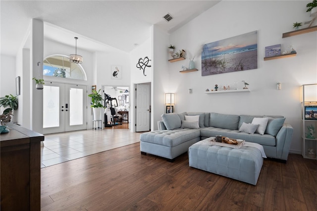 living room featuring wood-type flooring, high vaulted ceiling, and french doors