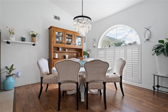 dining room with vaulted ceiling, a chandelier, and dark hardwood / wood-style flooring