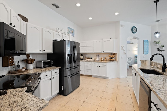 kitchen with sink, light stone counters, decorative light fixtures, appliances with stainless steel finishes, and white cabinets