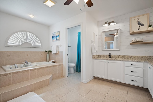 bathroom featuring vanity, toilet, tile patterned flooring, and tiled bath