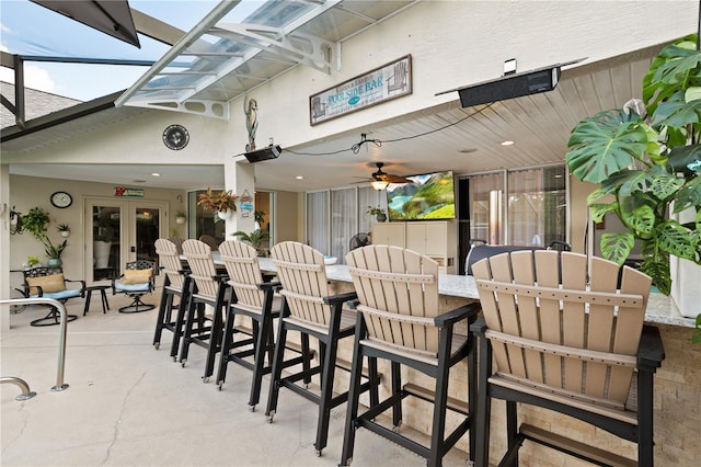 view of patio featuring french doors, ceiling fan, and exterior bar