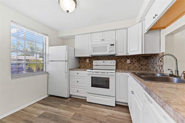 kitchen with light hardwood / wood-style floors, white cabinets, sink, backsplash, and white appliances