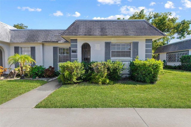 4220 Sheldon Pl Unit 4220, New Port Richey, FL 34652 - view of front of property featuring mansard roof, stucco siding, and a front lawn
