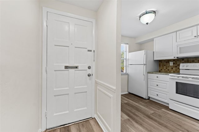 4220 Sheldon Pl Unit 4220, New Port Richey, FL 34652 - kitchen with white appliances, white cabinetry, light wood-style flooring, and tasteful backsplash