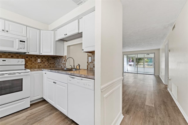 4220 Sheldon Pl Unit 4220, New Port Richey, FL 34652 - kitchen with white appliances, a sink, light wood-type flooring, backsplash, and white cabinets
