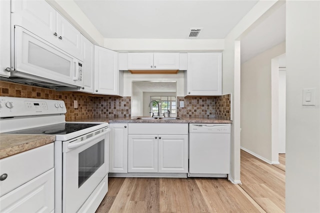 4220 Sheldon Pl Unit 4220, New Port Richey, FL 34652 - kitchen with white appliances, a sink, light wood finished floors, backsplash, and white cabinets