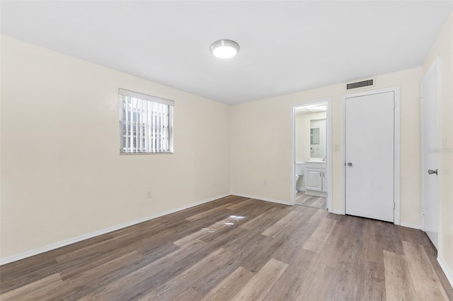4220 Sheldon Pl Unit 4220, New Port Richey, FL 34652 - unfurnished bedroom with wood finished floors, baseboards, and ensuite bath