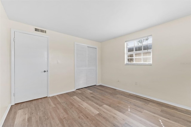 4220 Sheldon Pl Unit 4220, New Port Richey, FL 34652 - unfurnished bedroom with light wood finished floors, baseboards, and a closet