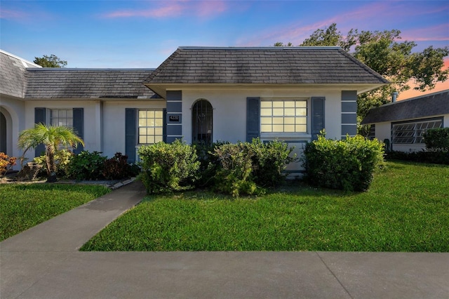 4220 Sheldon Pl Unit 4220, New Port Richey, FL 34652 - view of front of property with mansard roof, stucco siding, and a yard