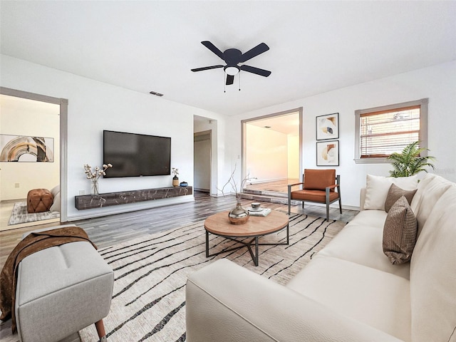 living room featuring hardwood / wood-style floors and ceiling fan