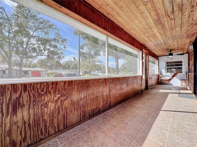 unfurnished sunroom featuring ceiling fan and wooden ceiling