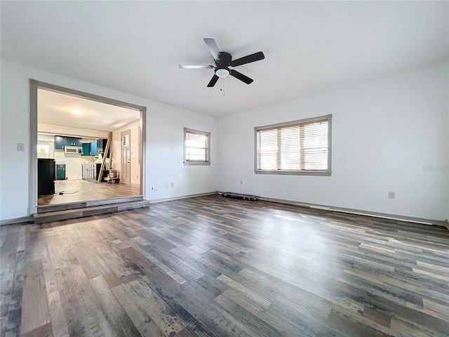 unfurnished room with ceiling fan and dark wood-type flooring