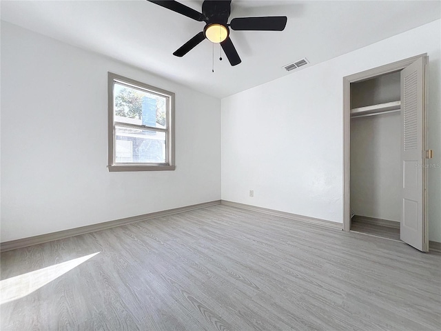 unfurnished bedroom with a closet, light hardwood / wood-style flooring, and ceiling fan