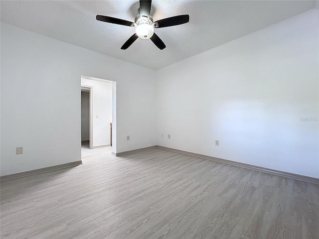 spare room featuring a textured ceiling, light hardwood / wood-style floors, and ceiling fan