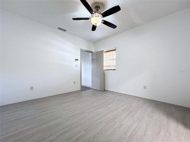 empty room featuring ceiling fan, a textured ceiling, and light wood-type flooring