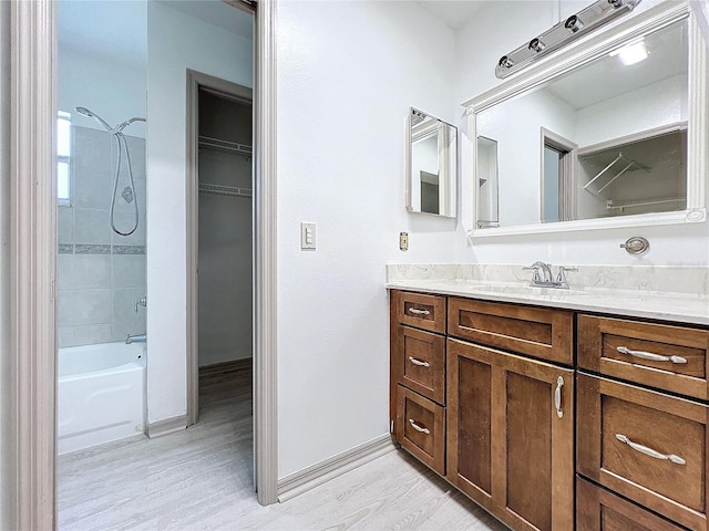 bathroom featuring vanity, tiled shower / bath combo, and hardwood / wood-style flooring