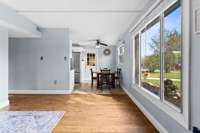 dining room featuring ceiling fan, plenty of natural light, light hardwood / wood-style floors, and vaulted ceiling