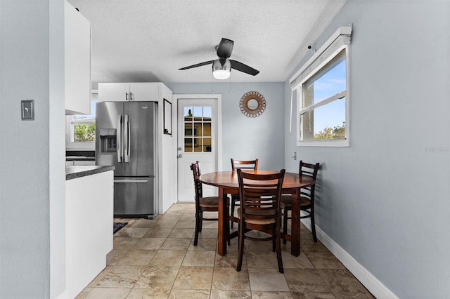 dining room featuring ceiling fan and a textured ceiling