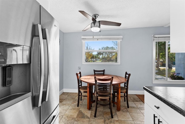 dining area featuring a wealth of natural light, ceiling fan, and a textured ceiling