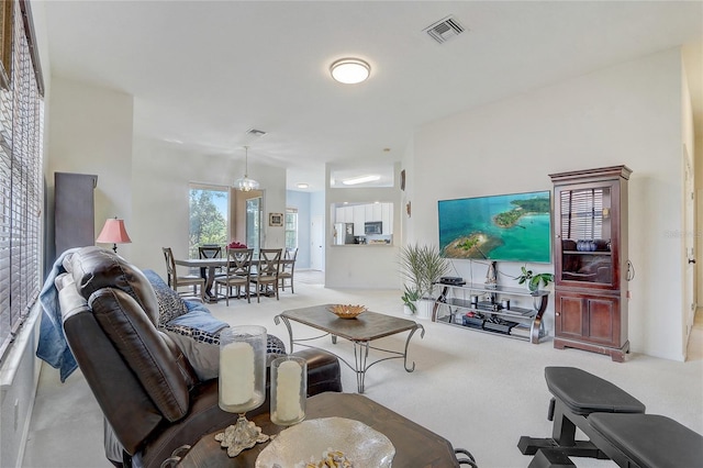 carpeted living room with a chandelier